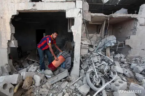 A Palestinian man inspects the rubble of Tayseer Al-Batsh's family house, which police said was destroyed in an Israeli air strike in Gaza City July 13, 2014. The Israeli air strike on the home of Al-Batsh, Gaza's police...