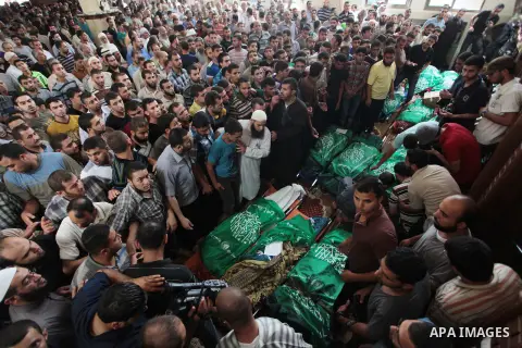 Palestinians pray near the bodies of Palestinian members of Tayseer Al-Batsh's family, who hospital officials said were killed in an Israeli air strike, during their funeral at a mosque in Gaza City July 13, 2014. The Is...