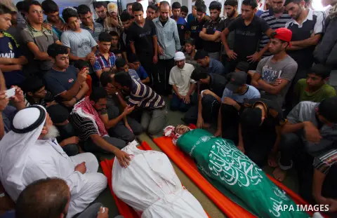 Palestinian mourners at a mosque gather around the bodies of Mousa Abu Muamer, 56, and his son, Saddam, 27, who were killed in an overnight Israeli missile strike at their house in the outskirts of the town of Khan Youni...
