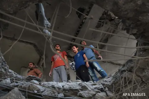 Palestinians inspect the remains of a house which police said was destroyed in an Israeli air strike in Gaza City July 15, 2014. Israel approved an Egyptian-proposed deal that would halt the week-old Gaza shelling war on...