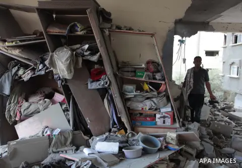 Palestinians inspect the remains of a house which police said was destroyed in an Israeli air strike in Gaza City July 15, 2014. Israel approved an Egyptian-proposed deal that would halt the week-old Gaza shelling war on...