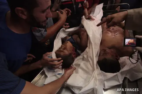 Relatives of one of four Palestinian children from the Baker family, whom medics said were killed by a shell fired by an Israeli naval gunboat check at the morgue in Gaza City July 16, 2014. The four Palestinian children...