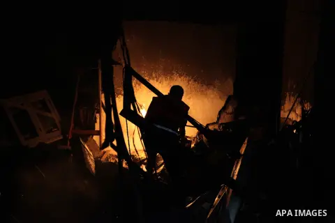 A Palestinian firefighter extinguishes a fire at a Currency exchange shop destroyed during an Israeli strike, on July 17, 2014, in Gaza City. Israeli shelling killed four Palestinian boys on a Gaza beach on Wednesday, an...