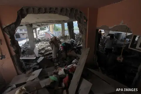 A Palestinian woman reacts next to debris in her house, which police said was targeted in an Israeli air strike, in Gaza City July 17, 2014. Israeli shelling killed four Palestinian boys on a Gaza beach on Wednesday, an...