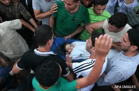 Palestinians carry the body of a boy from the Shaibar family, whom medics said was killed along with two other children from the same family by an Israeli air strike after the end of a five-hour humanitarian ceasefire, d...