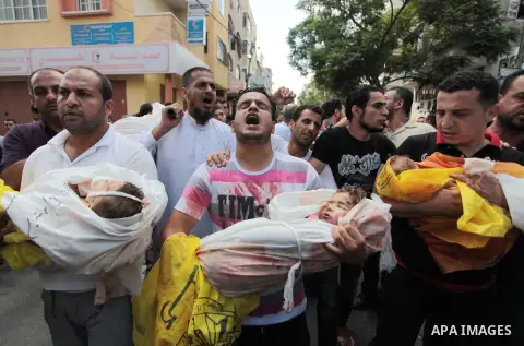 Palestinian relatives shout as they carry the bodies of kids during the funeral of eight members of Abu Jarad family who were killed overnight in an Israeli strike on July 19, 2014 in Beit Lahia, north of the Gaza strip....