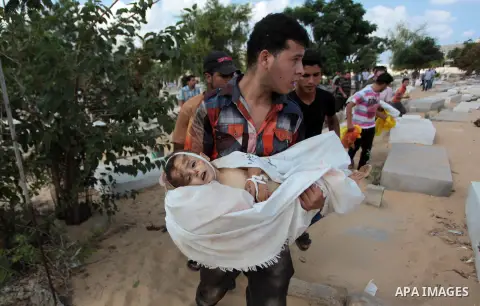 Palestinian relatives burry the bodies of two kids during the funeral of eight members of Abu Jarad family who were killed overnight in an Israeli strike on July 19, 2014 in Beit Lahia, north of the Gaza strip. The new d...