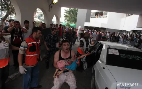 A Palestinian man reacts as he carries the body of his daughter, whop was killed during Israeli shelling, outside at al-Shifa hospital in Gaza City on July 20, 2014. Israel's army said it was expanding its ground offensi...