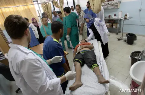 A Palestinian boy from al-Shaer family, who medics said was wounded after an Israeli air strike hit their house, receives treatment at a hospital in Khan Younis in the southern Gaza Strip July 20, 2014. The death toll in...