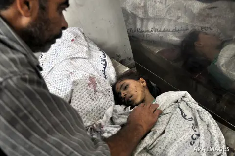 Palestinians inspect the bodies of their relatives at the morgue of the al-Shifa hospital in Gaza City, on July 20, 2014 July 20, 2014. The death toll in Gaza passed 400 as Israel pressed its biggest offensive in the enc...
