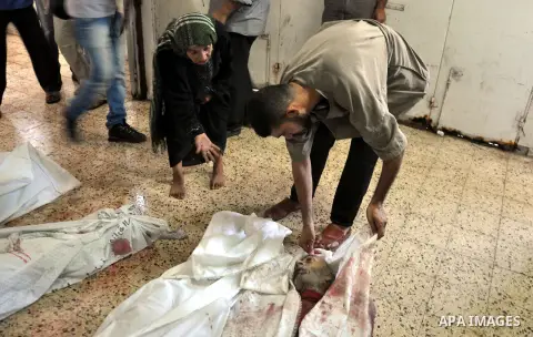 Palestinians inspect the bodies of their relatives at the morgue of the al-Shifa hospital in Gaza City, on July 20, 2014 July 20, 2014. The death toll in Gaza passed 400 as Israel pressed its biggest offensive in the enc...