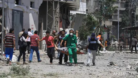 Medics evacuate an injured man from Gaza's eastern Shejaiya district on July 20, 2014. At least 40 people were killed and nearly 400 wounded in Israeli shelling of Gaza's northeastern Shejaiya district overnight, medics...
