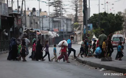 Palestinians who flew from the Shuja'iyya neighbourhood walk on a street in east Gaza City, 20 July 2014. Tens of thousand of Palestinians living in the area which is in close proximity left their houses in the past days...