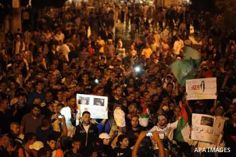 Palestinians shout slogans during a protest in front of the Dome of the Rock at the Al-Aqsa Mosque compound in the Old City of Jerusalem on July 20, 2014, in protest against Israel's military operation in the Gaza Strip....