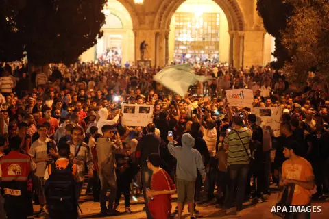 Palestinians shout slogans during a protest in front of the Dome of the Rock at the Al-Aqsa Mosque compound in the Old City of Jerusalem on July 20, 2014, in protest against Israel's military operation in the Gaza Strip....