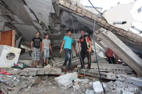Palestinian rescuers search for bodies and survivors in the rubble of homes which were destroyed by an Israeli missile strike, in Gaza City, Monday, July 21, 2014. On Sunday, the first major ground battle in two weeks of...