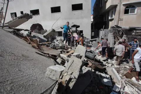 Palestinian rescuers search for bodies and survivors in the rubble of homes which were destroyed by an Israeli missile strike, in Gaza City, Monday, July 21, 2014. On Sunday, the first major ground battle in two weeks of...