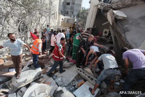 Palestinian rescuers search for bodies and survivors in the rubble of homes which were destroyed by an Israeli missile strike, in Gaza City, Monday, July 21, 2014. On Sunday, the first major ground battle in two weeks of...