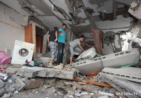 Palestinian rescuers search for bodies and survivors in the rubble of homes which were destroyed by an Israeli missile strike, in Gaza City, Monday, July 21, 2014. On Sunday, the first major ground battle in two weeks of...