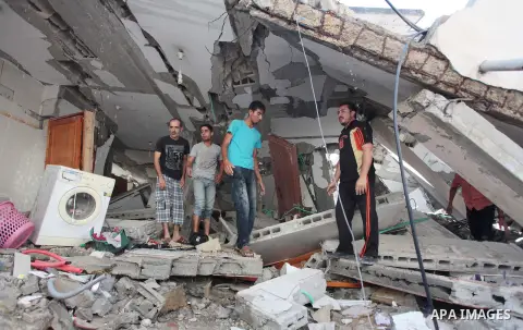 Palestinian rescuers search for bodies and survivors in the rubble of homes which were destroyed by an Israeli missile strike, in Gaza City, Monday, July 21, 2014. On Sunday, the first major ground battle in two weeks of...