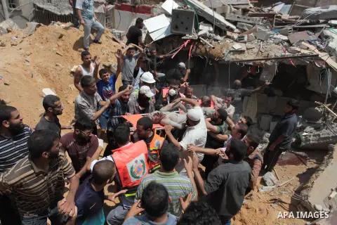 Palestinian rescue workers and civilians remove a lifeless body from the rubble of a house was destroyed by an Israeli missile strike, in Gaza City, Monday, July 21, 2014. On Sunday, the first major ground battle in two...