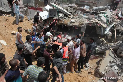 Palestinian rescue workers and civilians remove a lifeless body from the rubble of a house was destroyed by an Israeli missile strike, in Gaza City, Monday, July 21, 2014. On Sunday, the first major ground battle in two...