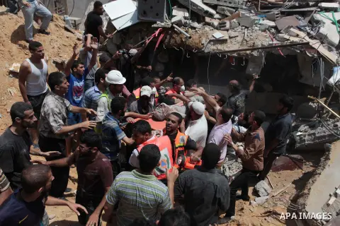 Palestinian rescue workers and civilians remove a lifeless body from the rubble of a house was destroyed by an Israeli missile strike, in Gaza City, Monday, July 21, 2014. On Sunday, the first major ground battle in two...