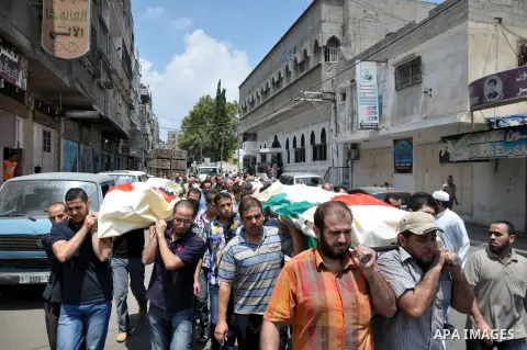Mourners carry the bodies of Palestinian from al-Halaq family, who medics said were killed in an Israeli air strike on Sunday along with seven members from the same family, during their funeral in Gaza City July 21, 2014...