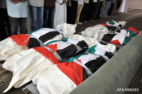 Palestinians pray next to the bodies of eight members from al-Halaq family, who medics said were killed in an Israeli air strike on Sunday, during their funeral at a mosque in Gaza City July 21, 2014. Israeli forces kill...