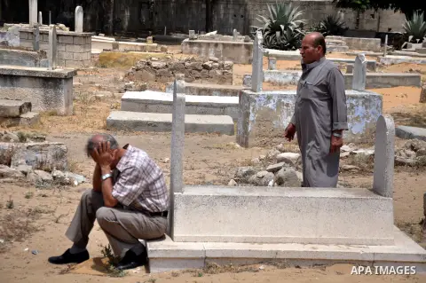 Relatives mourn on the bodies of Palestinian from al-Halaq family, who medics said were killed in an Israeli air strike on Sunday along with seven members from the same family during heavy Israeli shelling, at a cemetery...