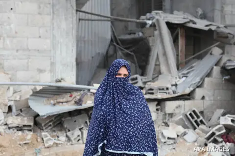 A Palestinian woman looks on as she stands in front of a three-storey house belonging to the Abu Jamaa family that was destroyed the day before following heavy Israeli bombardment, in Khan Yunis, in the southern Gaza Str...