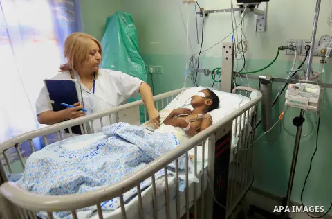 A Palestinian an injured lies on a bed after being wounded by an Israeli air strike in Gaza strip, at al-Makassed hospital, in Jersalem, on July 21, 2014. Israeli forces killed at least 10 Palestinian militants on Monday...