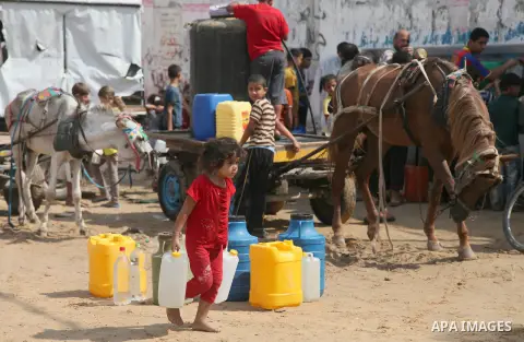 Palestinians fill bottles and containers with water from a public tap in in Khan Yunis, in the southern Gaza Strip July 21, 2014. Israeli forces killed at least 10 Palestinian militants on Monday after they crossed the b...
