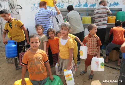 Palestinians fill bottles and containers with water from a public tap in in Khan Yunis, in the southern Gaza Strip July 21, 2014.Israeli forces killed at least 10 Palestinian militants on Monday after they crossed the bo...