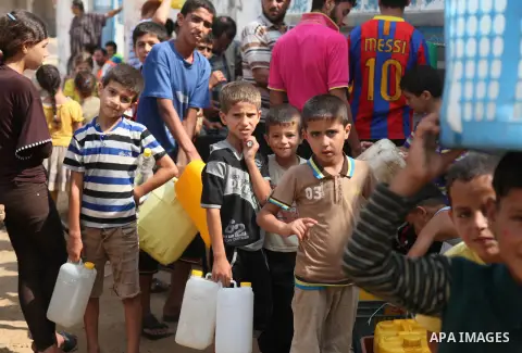 Palestinians fill bottles and containers with water from a public tap in in Khan Yunis, in the southern Gaza Strip July 21, 2014. Israeli forces killed at least 10 Palestinian militants on Monday after they crossed the b...