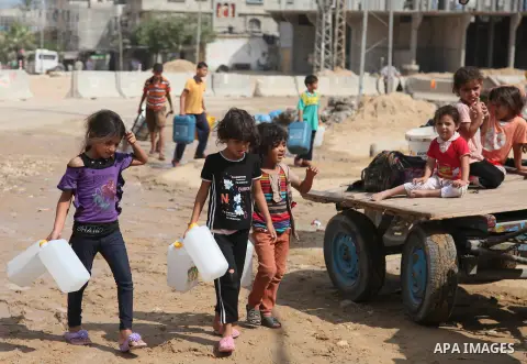 Palestinians fill bottles and containers with water from a public tap in in Khan Yunis, in the southern Gaza Strip July 21, 2014. Israeli forces killed at least 10 Palestinian militants on Monday after they crossed the b...