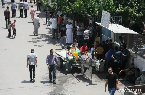 Palestinians fill bottles and containers with water from a public tap in in Khan Yunis, in the southern Gaza Strip July 21, 2014. Israeli forces killed at least 10 Palestinian militants on Monday after they crossed the b...