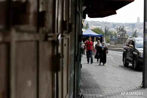 Palestinians walk past closed shops at a market in Jerusalem old city on 21 July 2014. Shops were shut in the West Bank cites and Jerusalem in solidarity with the at least 60 Palestinians who were killed in the neighbour...