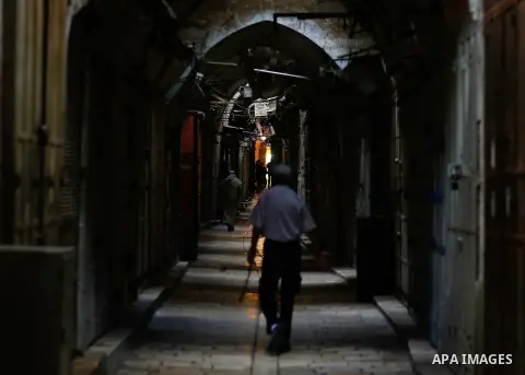 Palestinians walk past closed shops at a market in Jerusalem old city on 21 July 2014. Shops were shut in the West Bank cites and Jerusalem in solidarity with the at least 60 Palestinians who were killed in the neighbour...