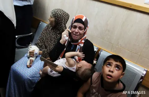 Palestinian patients react as they sit at a hall of the Al-Aqsa Martyrs hospital in Deir al-Balah, in the central Gaza Strip, after the building was hit by an Israeli army shelling on July 21, 2014, killing five people a...