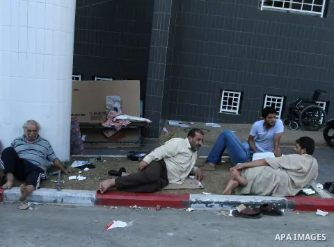 Displaced Palestinians wait at al-Shifa hospital where they have taken refuge after fleeing heavy fighting in their area, in Gaza City on July 21, 2014. The Palestinian death toll in an Israeli offensive in the Gaza Stri...