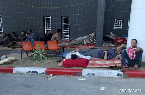 Displaced Palestinians wait at al-Shifa hospital where they have taken refuge after fleeing heavy fighting in their area, in Gaza City on July 21, 2014. The Palestinian death toll in an Israeli offensive in the Gaza Stri...