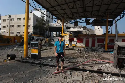 A Palestinian young man looks at a petrol station which police said was damaged in an Israeli air strike, in Gaza City July 22, 2014. Israel kept up its assaults in the Gaza Strip on Tuesday, killing three Palestinians i...