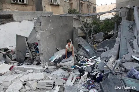 A Palestinian boy sits walk looking on as he searches the rubble of her family's destroyed apartment for belongings following an Israeli air strike in the center of Gaza City on July 22, 2014. A series of Israeli air str...