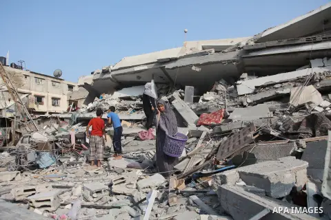 Palestinians search the rubble of their destroyed apartments for belongings following an Israeli air strike in the center of Gaza City on July 22, 2014. A series of Israeli air strikes early today killed at least seven p...