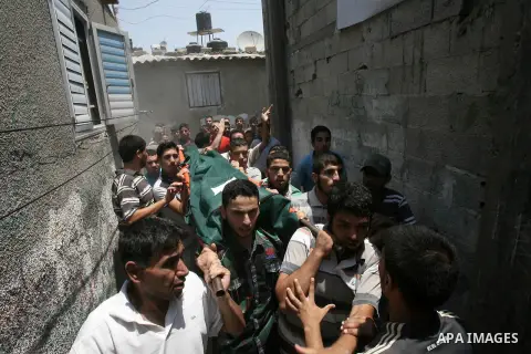 Palestinian mourners carry the body of Mohammed al-Hamaida after he was killed in an Israeli air strike, during his funeral on July 22, 2014, in Rafah town in the southern Gaza Strip. A series of Israeli air strikes earl...