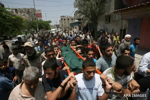 Palestinian mourners carry the body of Mohammed al-Hamaida after he was killed in an Israeli air strike, during his funeral on July 22, 2014, in Rafah town in the southern Gaza Strip. A series of Israeli air strikes earl...