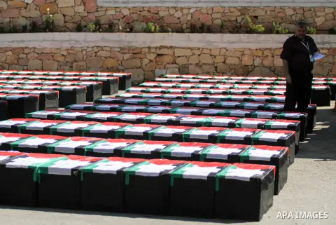 A Palestinian man stands near symbolic coffins during a protest in solidarity with Palestinians killed by Israeli forces in Gaza Strip, in the West Bank City of Ramallah on July 22, 2014. A series of Israeli air strikes...