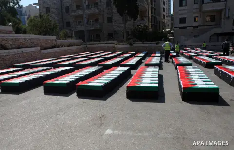 Palestinians prepare symbolic coffins during a protest in solidarity with Palestinians killed by Israeli forces in Gaza Strip, in the West Bank City of Ramallah on July 22, 2014. A series of Israeli air strikes early kil...