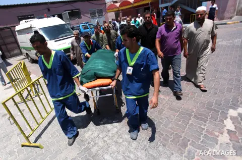 Palestinian medics carry the body of a man, who medics said he was wounded in an Israeli air strike, in Khan Younis in the southers Gaza Strip July 22, 2014. A series of Israeli air strikes early killed seven people in G...